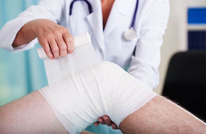 doctor vendando la articulación de la rodilla con artrosis